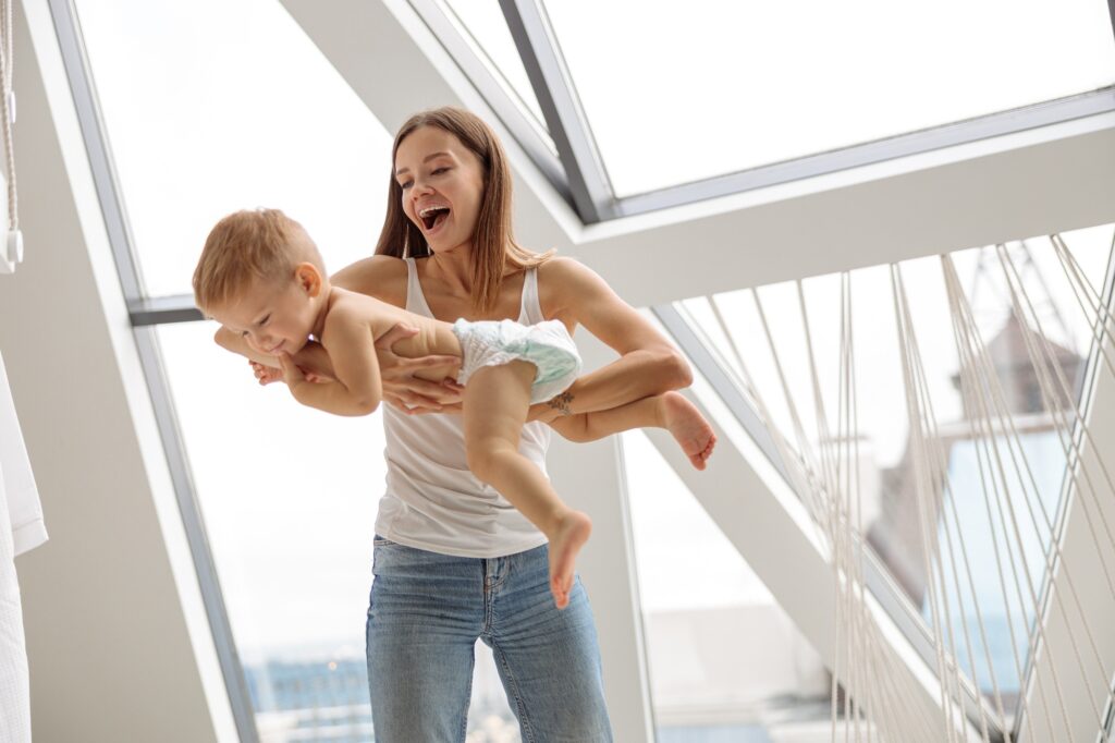 Happy Caucasian mother playing with her son indoor