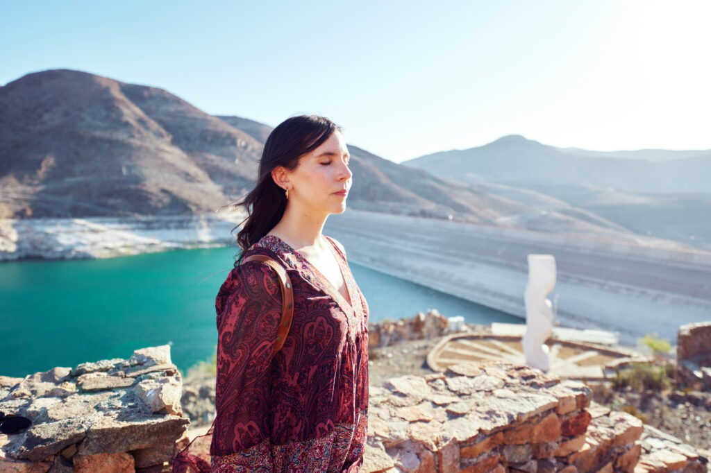 latin woman with eyes closed enjoying time outdoors in Huasco Valley