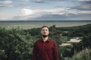 Man with closed eyes in rural landscape